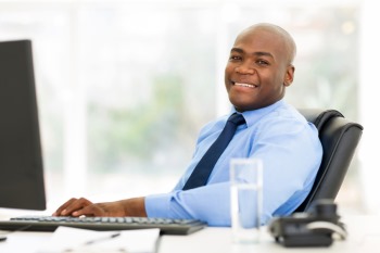 smiling african businessman sitting in office looking at the camera